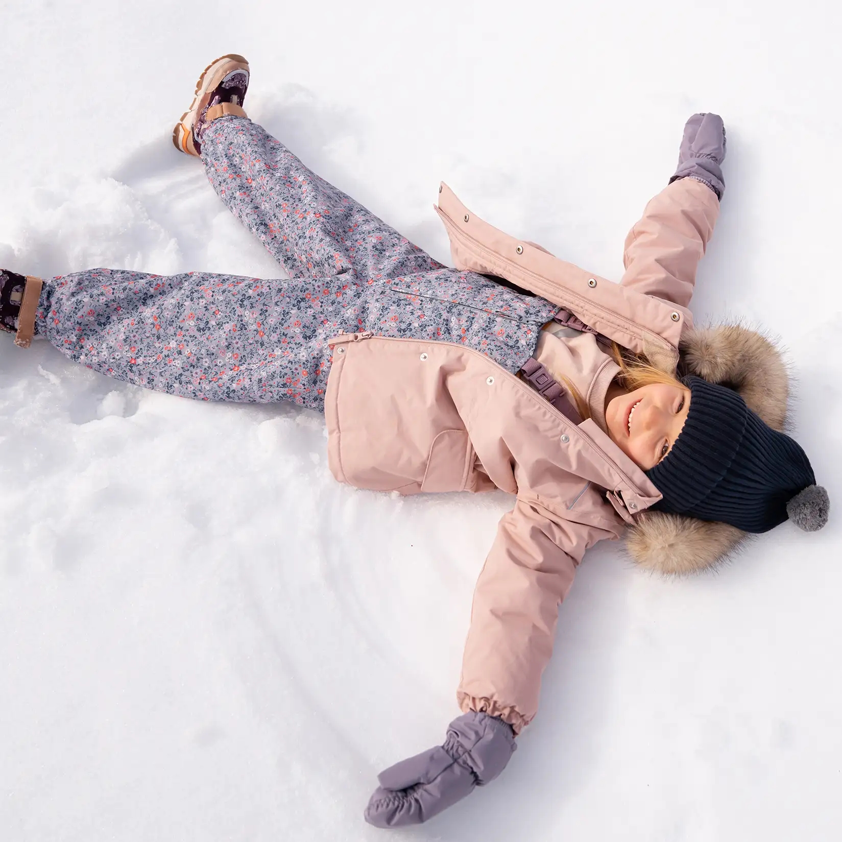 Barn i vandtæt overtøj der leger udenfor i snevejr